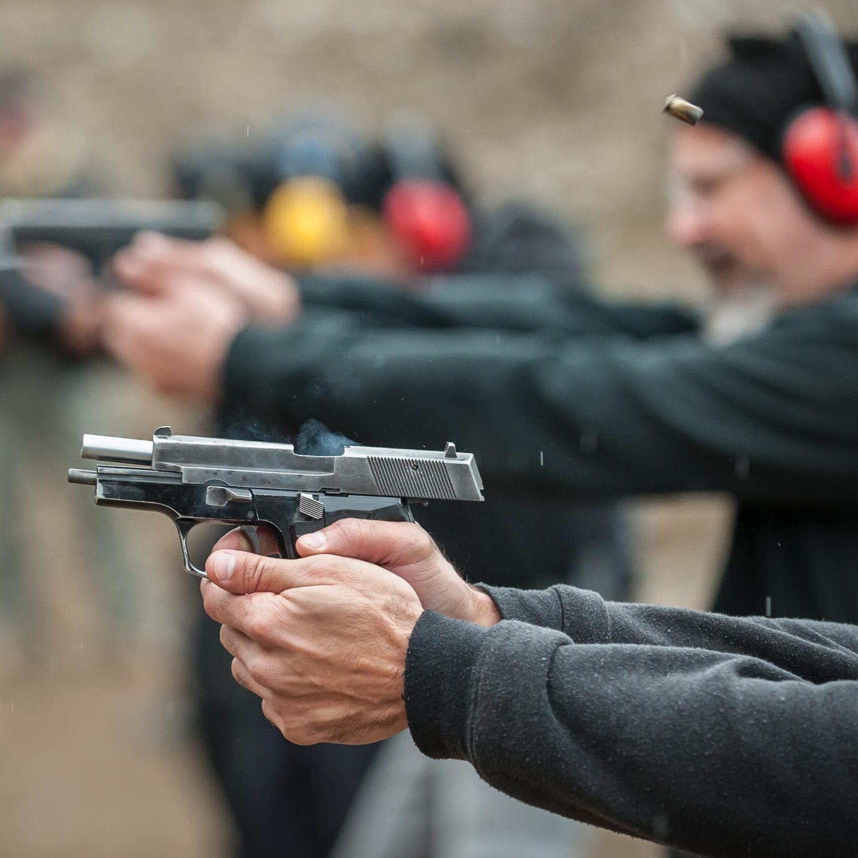 Group of civilian practice gun shoot on target on outdoor shooting range. Civilian team weapons training